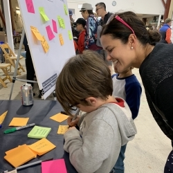 woman helping out a child writing a post it